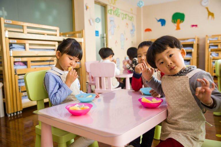 Three toddlers eating in a Japanese preschool