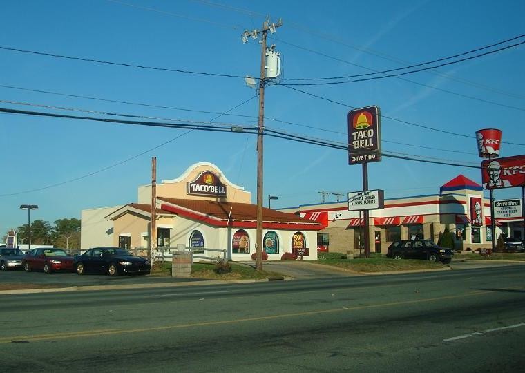 Street view of a Taco Bell with the older logo design including more muted colors.