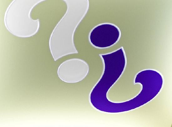 Close-up of a white question mark next to an inverted purple question mark on a light background.