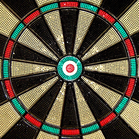 Close-up view of an electronic dartboard target face showing red, green, black, and white segments.